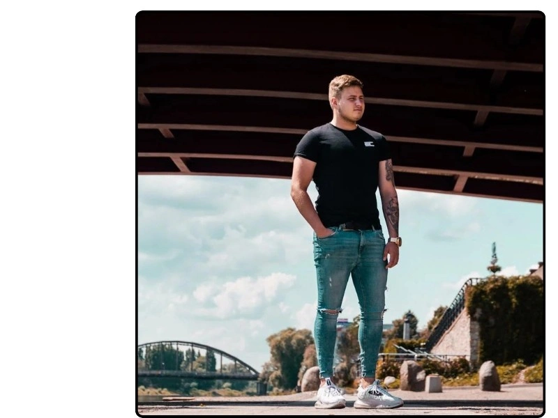 Stylish ripped jeans for men paired with a casual black t-shirt and sneakers, showcasing a modern streetwear look. Perfect for a relaxed yet fashionable outfit."