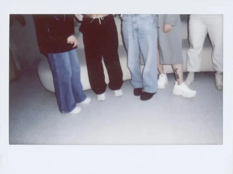 Group wearing a variety of stylish cargo trousers and jeans, featuring wide-leg and relaxed-fit styles paired with casual footwear, showcasing a trendy and comfortable streetwear look