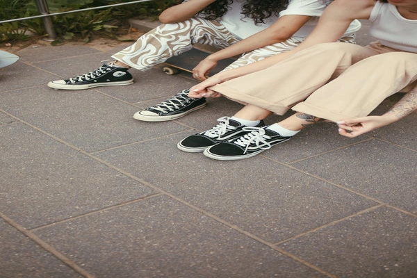 "Two people showcasing casual cargo trouser styles paired with sneakers, highlighting a relaxed and trendy streetwear look perfect for everyday comfort."