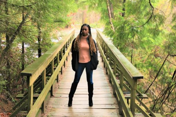 Stylish woman showcasing light wash black jeans in a modern outdoor setting, highlighting the versatility and casual-chic appeal of light wash black denim.